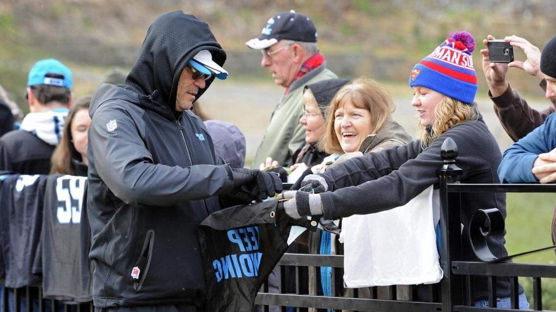 Carolina Panthers head coach Ron Rivera signs autographs for fans while walking to practice on Wednesday. He said he wants to keep his team outside in preparation for their NFC Championship game against the Arizona Cardinals – even if that means snow or freezing rain.