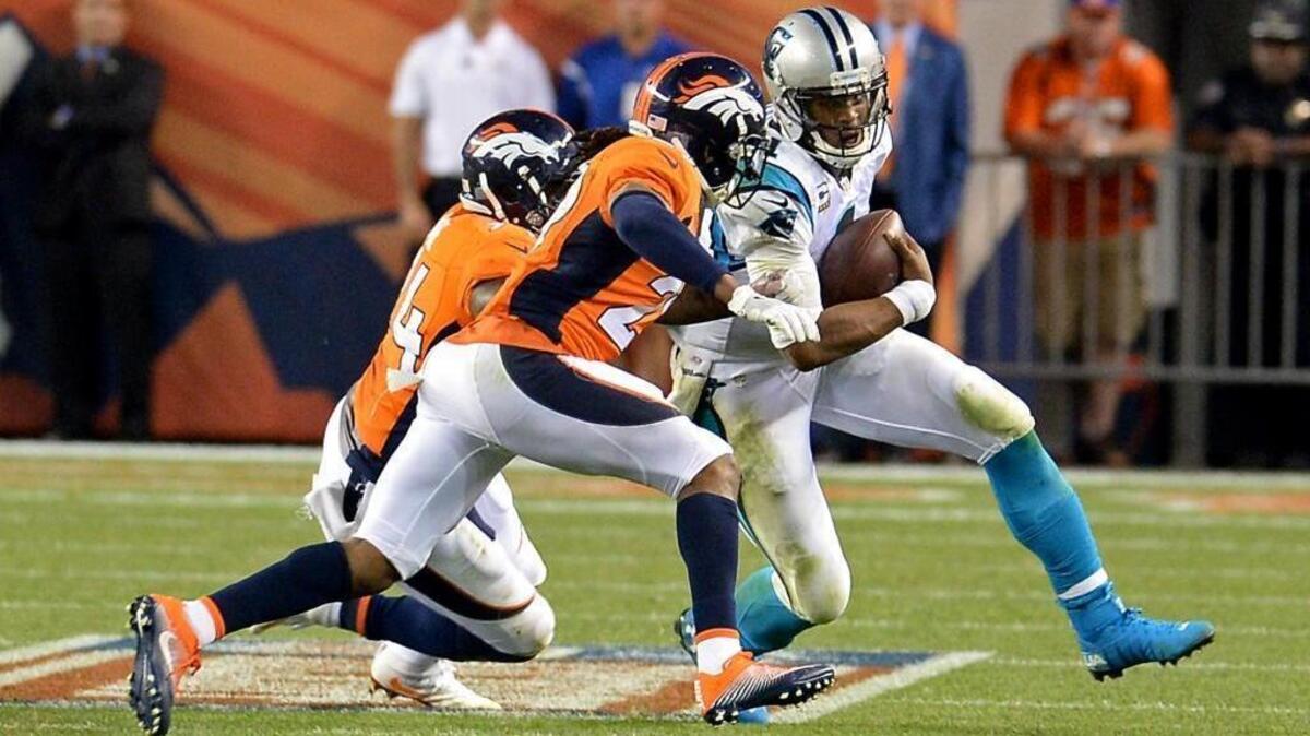 Carolina Panthers quarterback Cam Newton tries to run around Denver Broncos linebacker DeMarcus Ware, left and cornerback Bradley Roby, center, during the fourth quarter of Thursday’s game. Roby made helmet to helmet contact with Newton forcing him out of bounds.