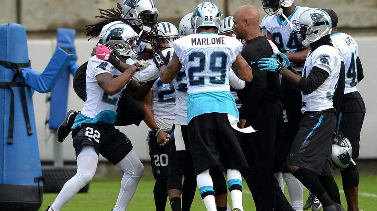 Carolina Panthers coach Eric Washington is surrounded by an energetic secondary during practice on Thursday.