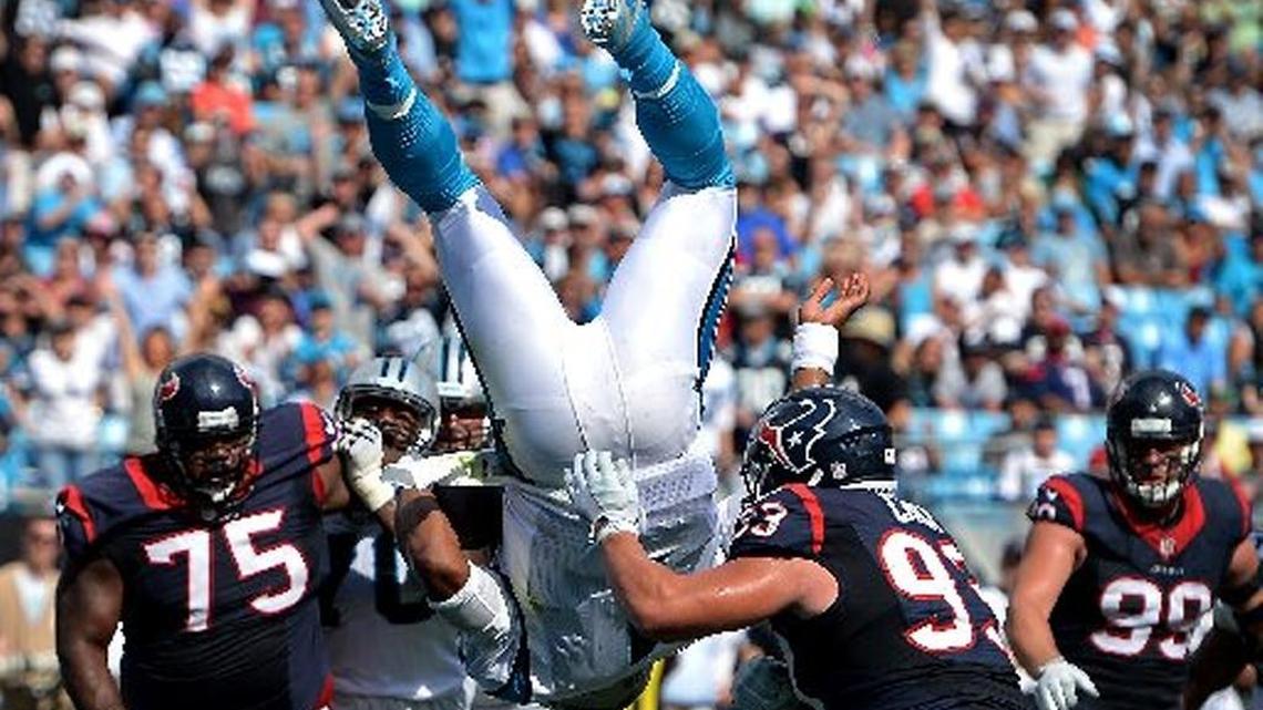 Carolina Panthers quarterback Cam Newton flips through the air over the goal line for a touchdown during third quarter action vs the Houston Texans at Bank of America Stadium in Charlotte, NC on Sunday, September 20, 2015. The Panthers defeated the Texans 24-17. Houston Texans defensive end Jared Crick, right, makes a hit on Newton.