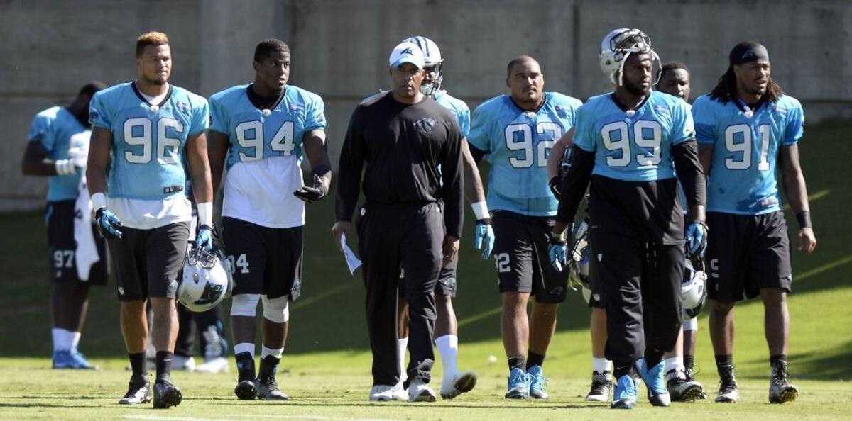 Eric Washington, center, was promoted last month to defensive coordinator after spending seven years coaching the Panthers’ defensive line.