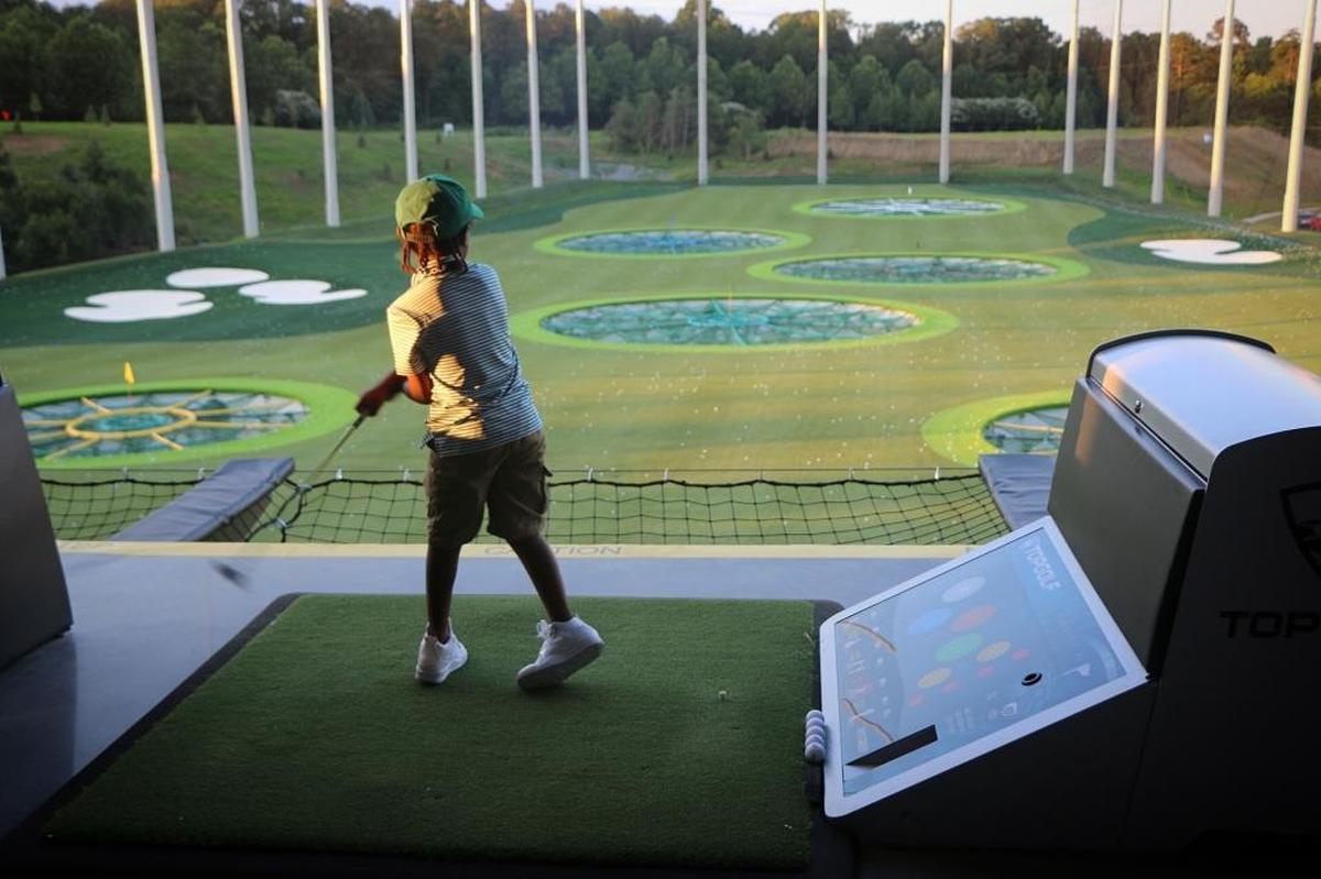 Charles Johnson snaps a photo of his son, Prince, at TopGolf.