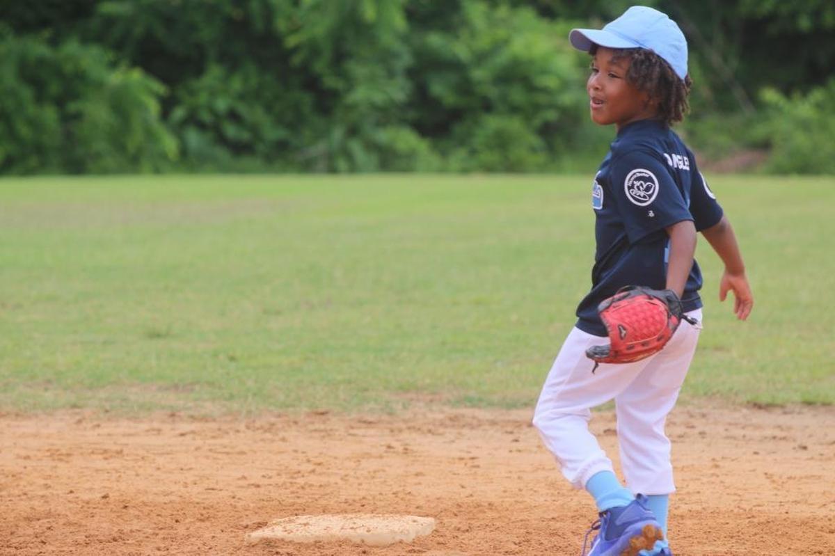 Prince Johnson shows off his baseball skills for his father’s camera.