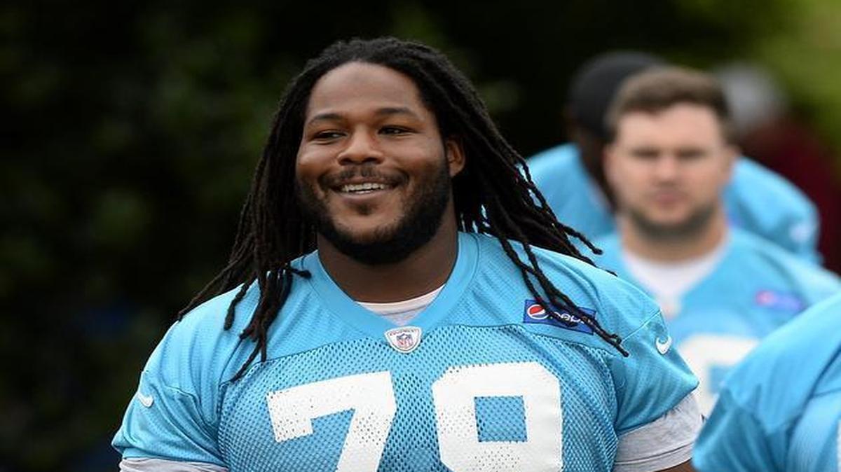 Carolina Panthers guard Chris Scott, left, smiles as he walks to practice with teammates in June.