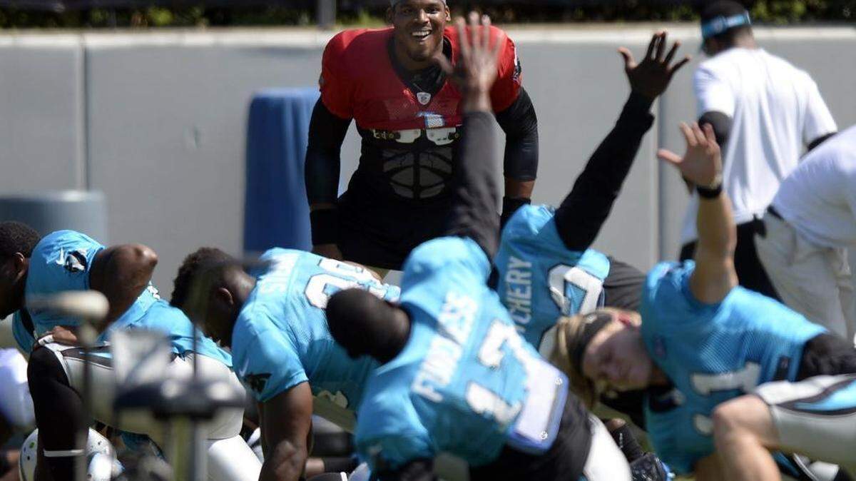 
Carolina Panthers' Cam Newton (1) jokes with teammates while warming up at the team's practice facility on Wednesday, September 9, 2015. 
