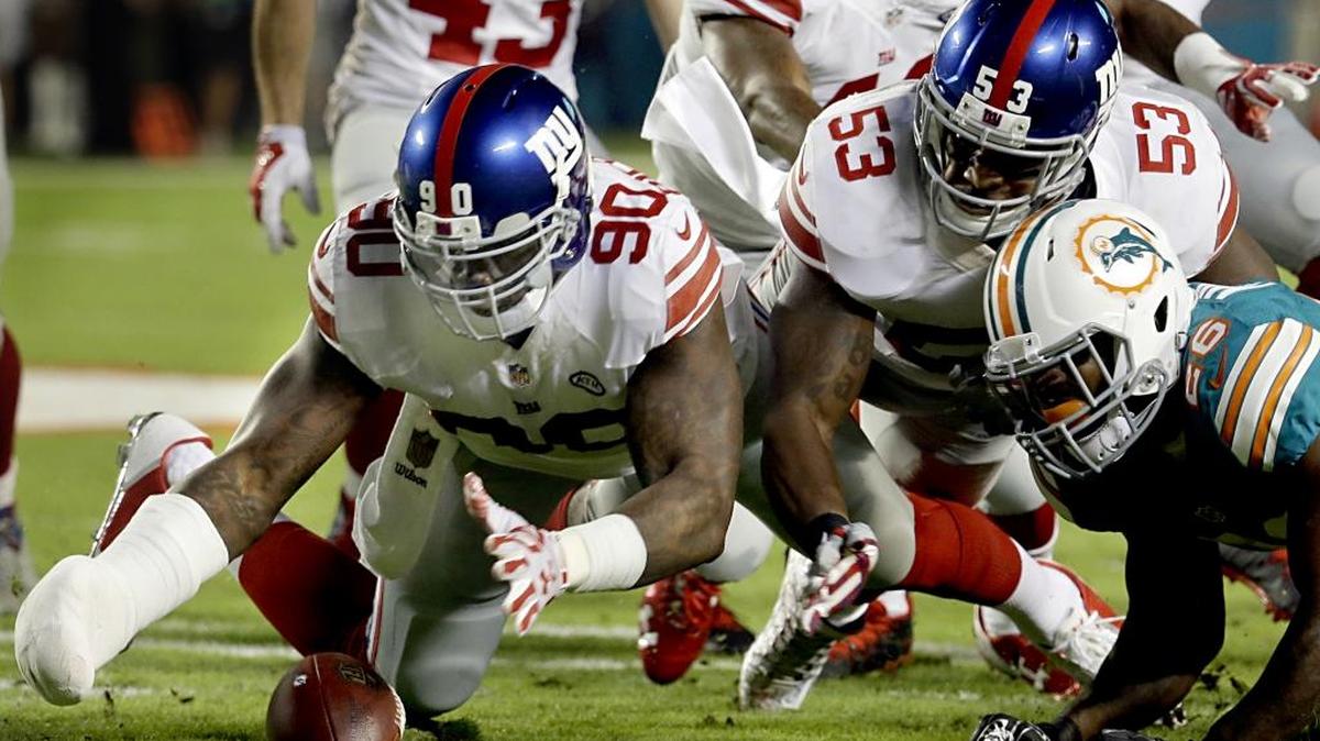 New York Giants defensive end Jason Pierre-Paul (90) recovers a fumble against Miami.
