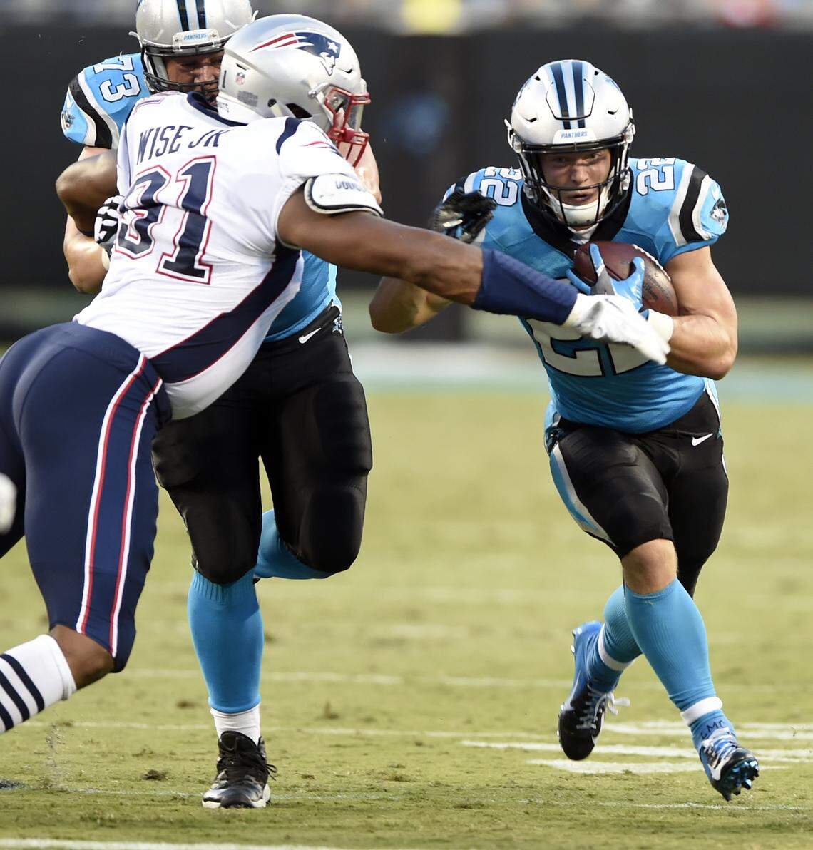 Carolina Panthers’ Christian McCaffrey (22) runs as New England Patriots’ Deatrich Wise (91) defends during the first half of a preseason NFL football game in Charlotte, N.C., Friday, Aug. 24, 2018. (AP Photo/Mike McCarn)