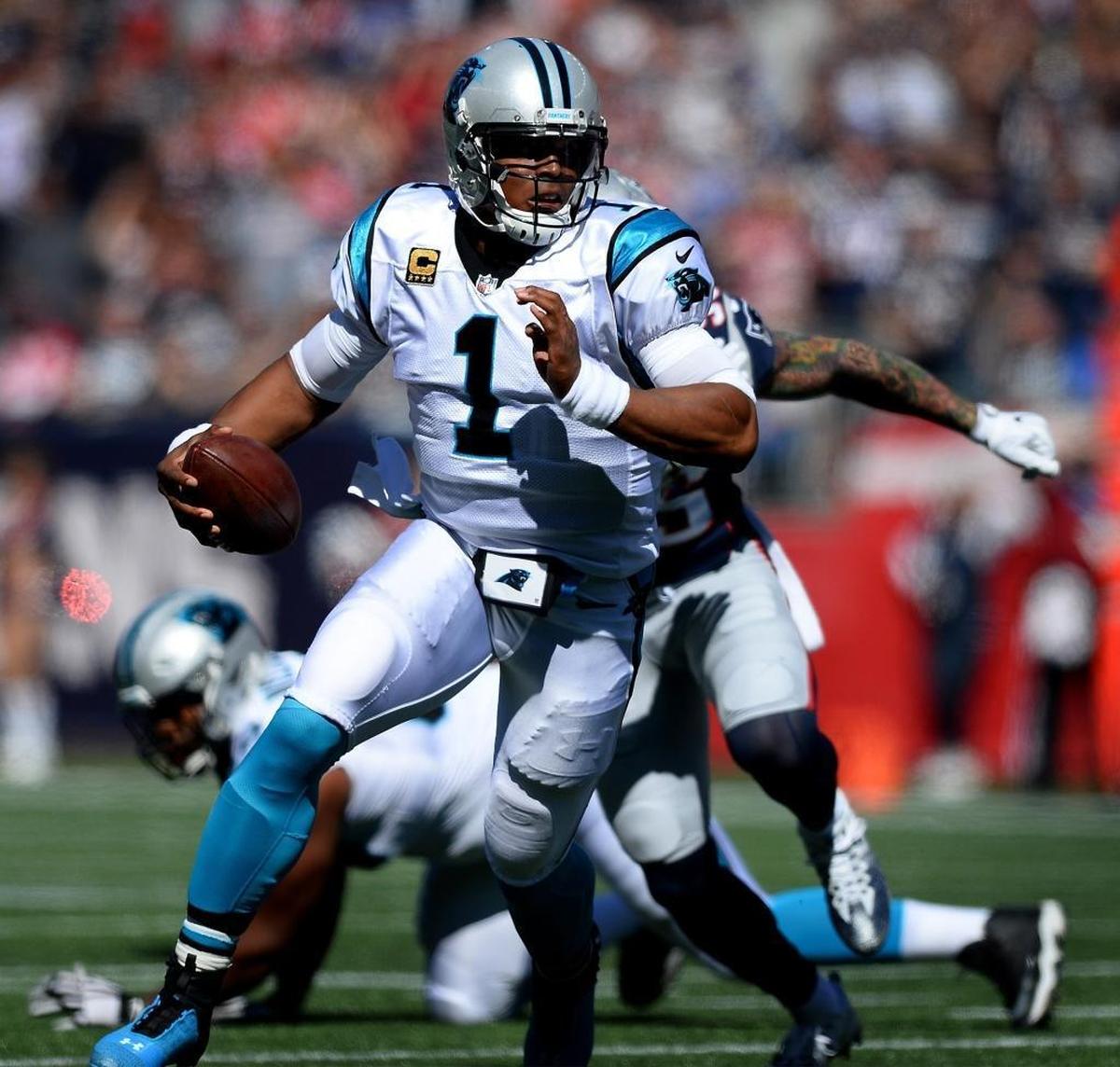 Quarterback Cam Newton looks for room to run Sunday during first-quarter action against the Patriots.