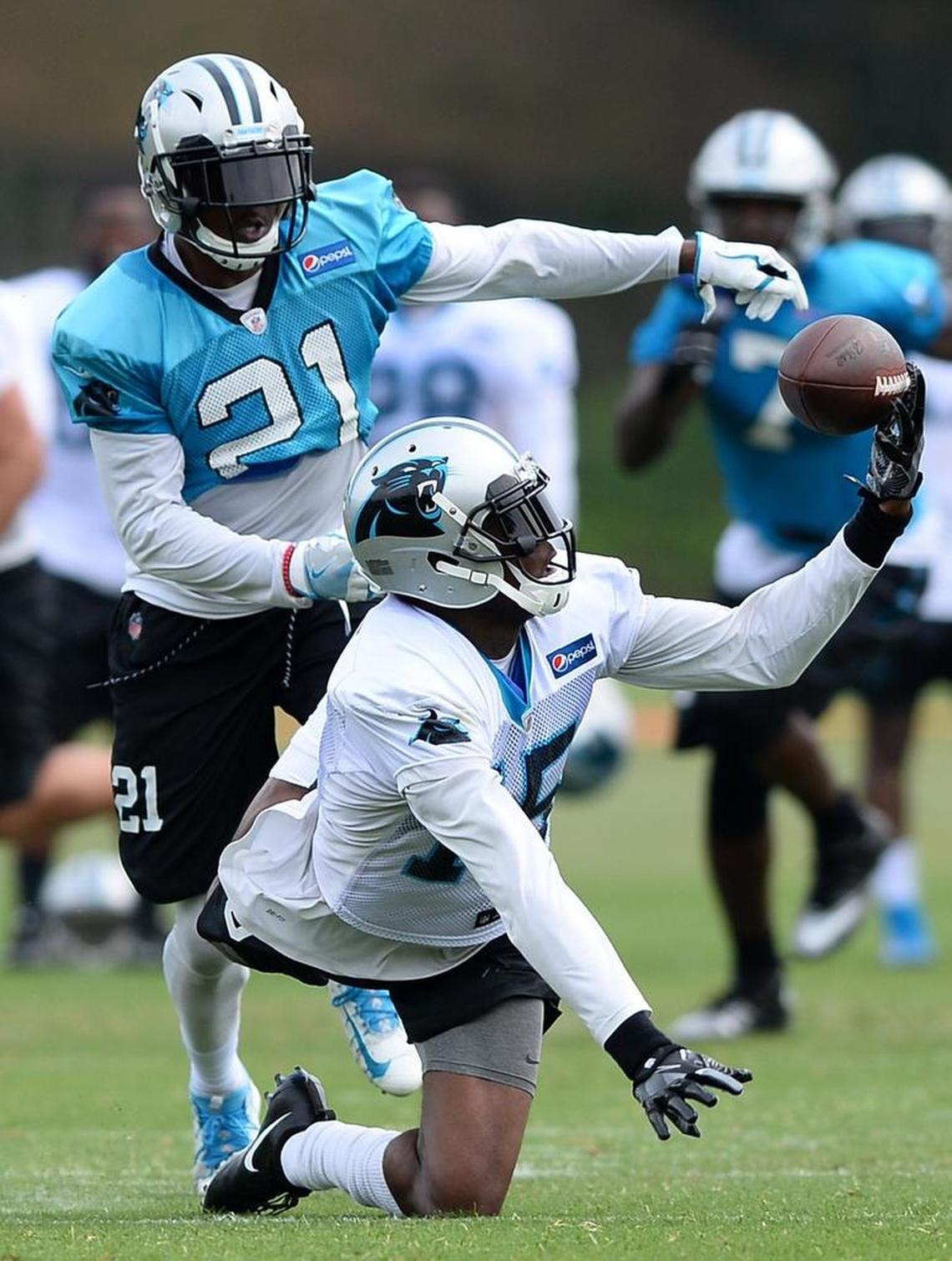 Carolina Panthers wide receiver Keyarris Garrett (15) tries to gain control of a pass as cornerback Teddy Williams, back/left, applies pressure early in training camp.