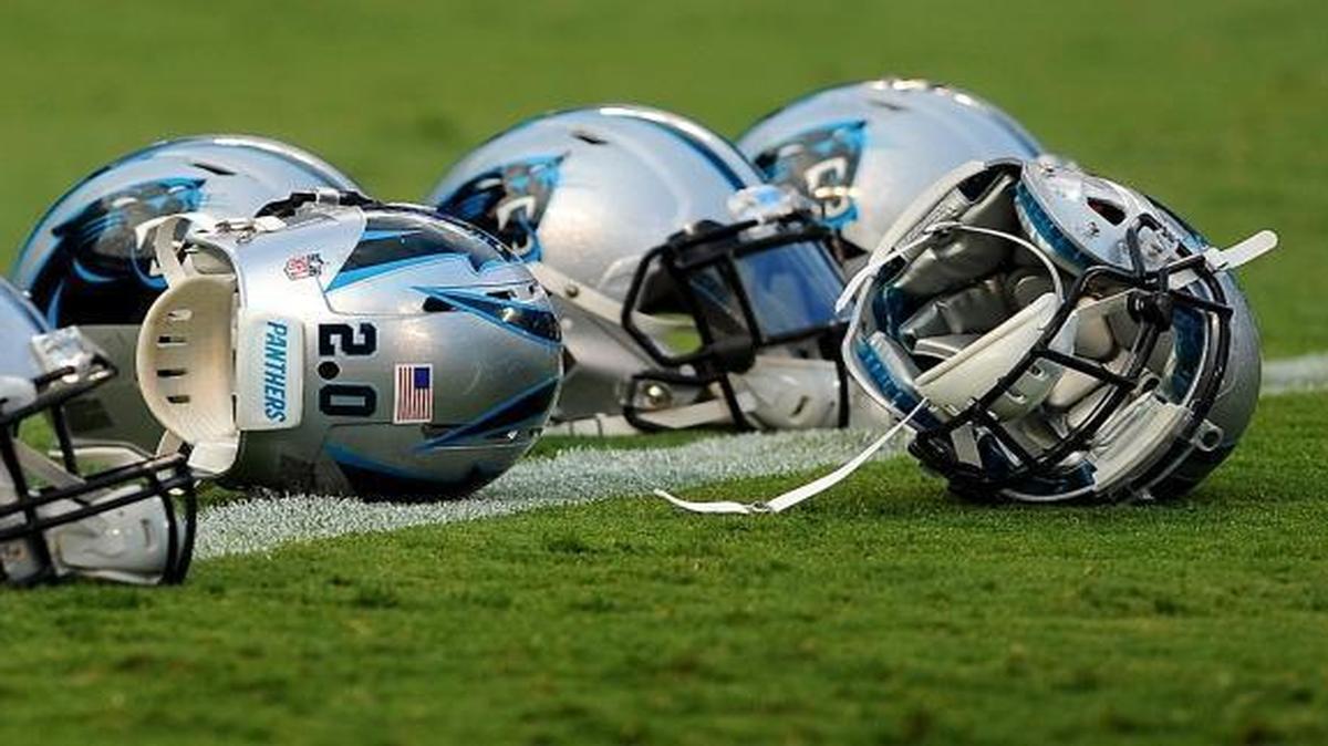 Carolina Panthers helmets rest on the field during Fan Fest at Bank of America Stadium.