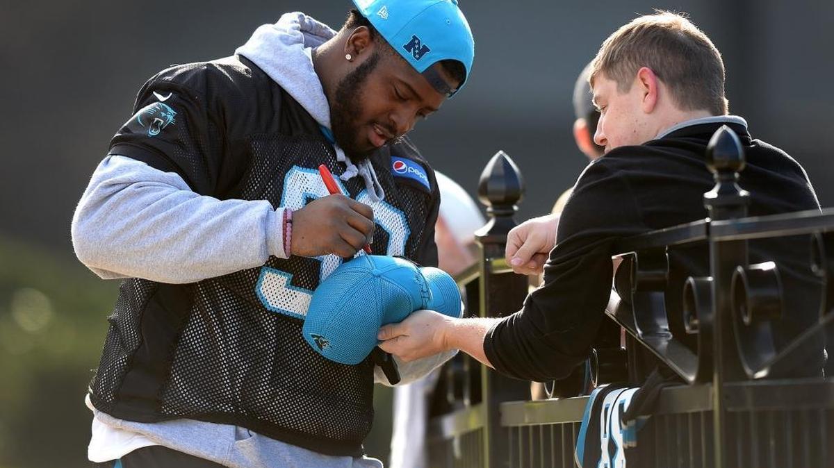 Carolina Panthers defensive tackle Kawann Short stops to sign autographs for fans before practice Thursday.
