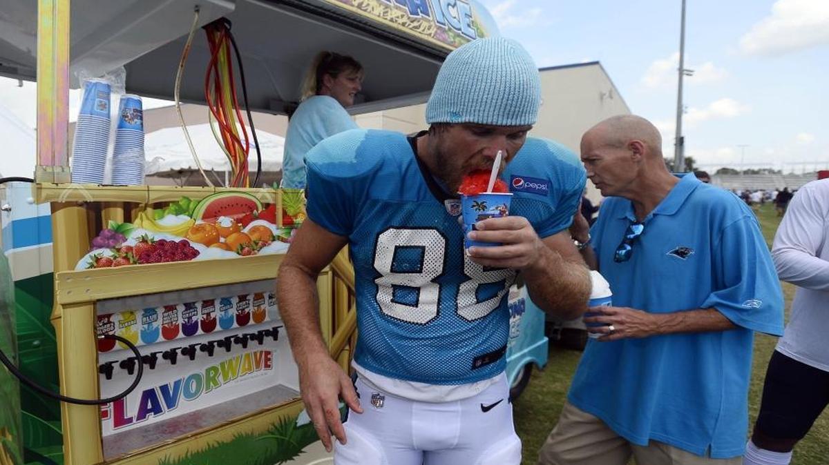 Carolina Panthers tight end Greg Olsen cools off with a snow cone after the Panthers' joint practice with the Tennessee Titans on Wednesday. Olsen had one of the day’s biggest plays with a catch of a tipped pass.