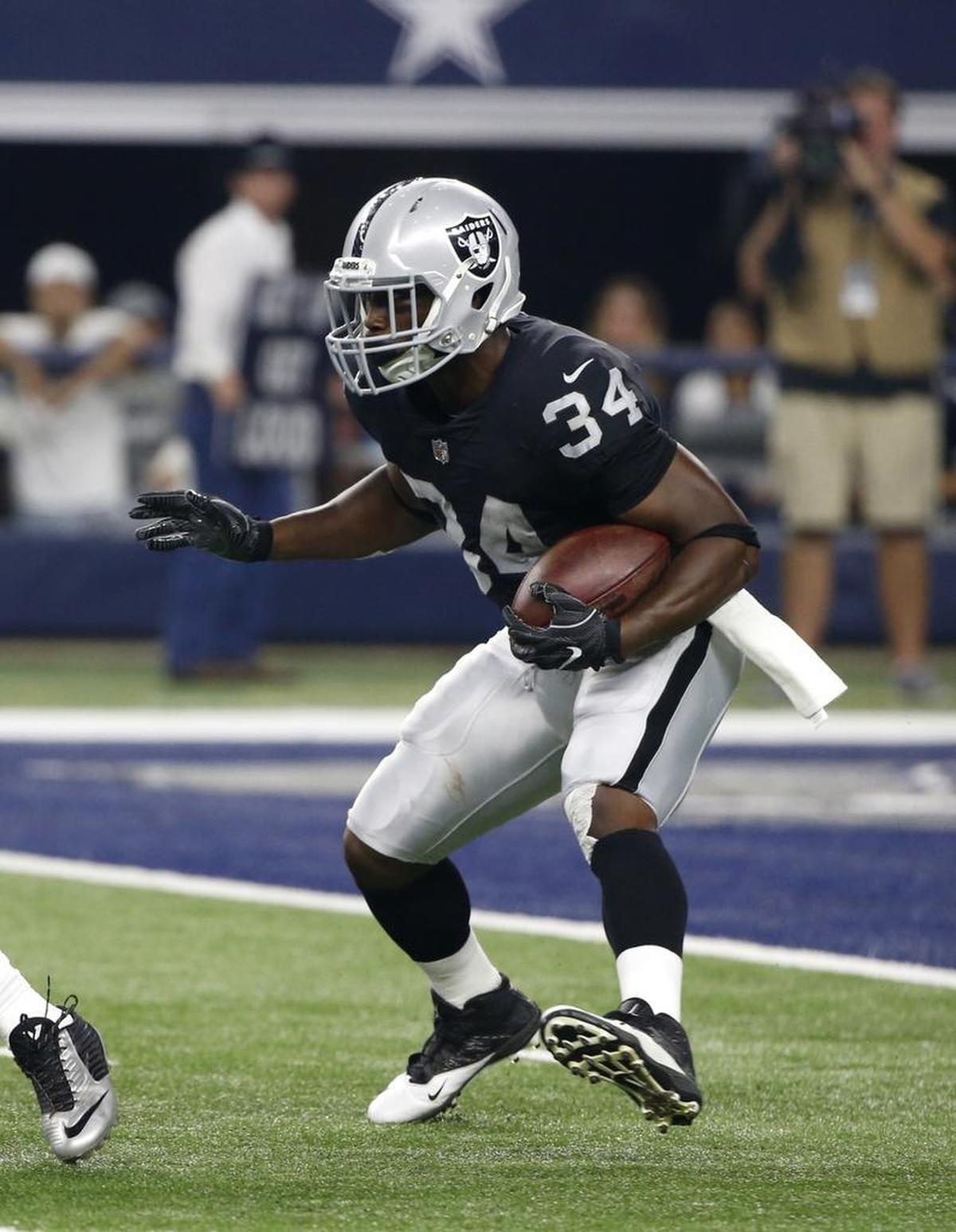 Oakland Raiders running back Elijah Hood (34) looks for running room against the Dallas Cowboys in the second half of a preseason NFL football game on Saturday.