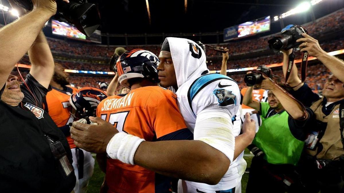 Carolina Panthers quarterback Cam Newton, right, hugs Denver Broncos quarterback Trevor Siemian, left, following Thursday’s game at Sports Authority Field at Mile High in Denver. The Broncos defeated the Panthers 21-20.
