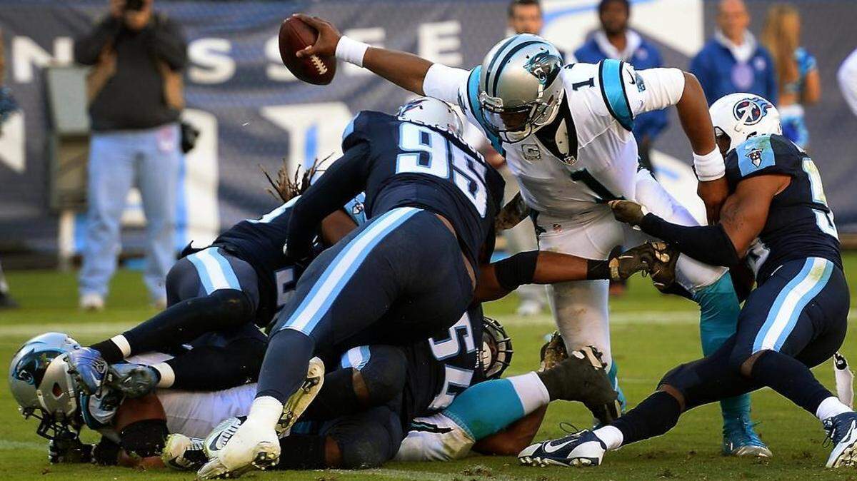 Carolina Panthers quarterback Cam Newton extends the ball across the goal line for a touchdown as the Tennessee Titans defense tries to make the tackle in the fourth quarter at Nissan Stadium in Nashville. The Panthers defeated the Titans 27-10.