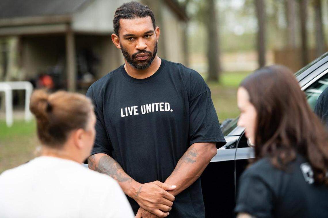 Carolina Panthers defensive end Julius Peppers, in Lumberton on Tuesday, teamed up with United Way to help residents who were affected by Hurricane Florence. Peppers is shown here listening to a woman whose house was flooded in the storm.