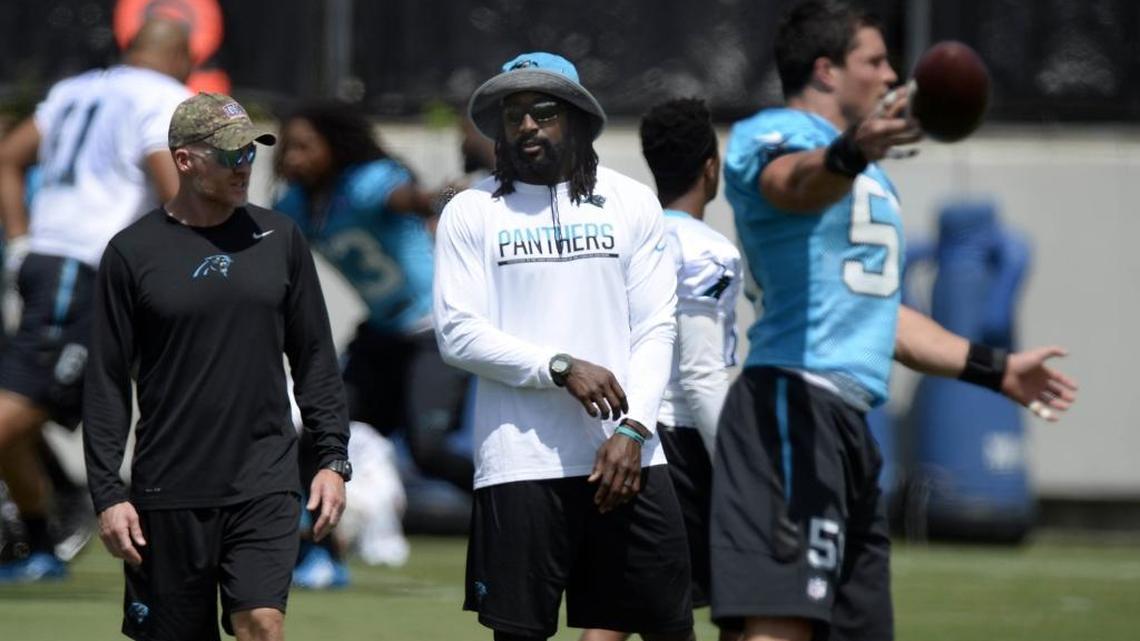 Former Carolina Panthers player Charles Tillman talks with defensive coordinator Sean McDermott while watching the current team warmup at the team's practice facility near Bank of America Stadium on Monday, August 22, 2016.