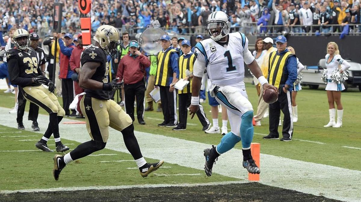 Cam Newton sticks his tongue out as he scores ahead of New Orleans’ Stephone Anthony (50) and Brandon Browner (39) during the fourth quarter at Bank of America Stadium on Sunday, September 27, 2015. The Panthers won, 27-22.