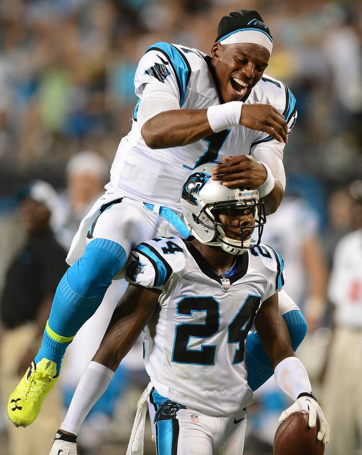 Quarterback Cam Newton, left, and cornerback Josh Newman played four seasons together with the Carolina Panthers. Above, they celebrate Norman’s interception against Pittsburgh in a 2013 exhibition at Bank of America Stadium.