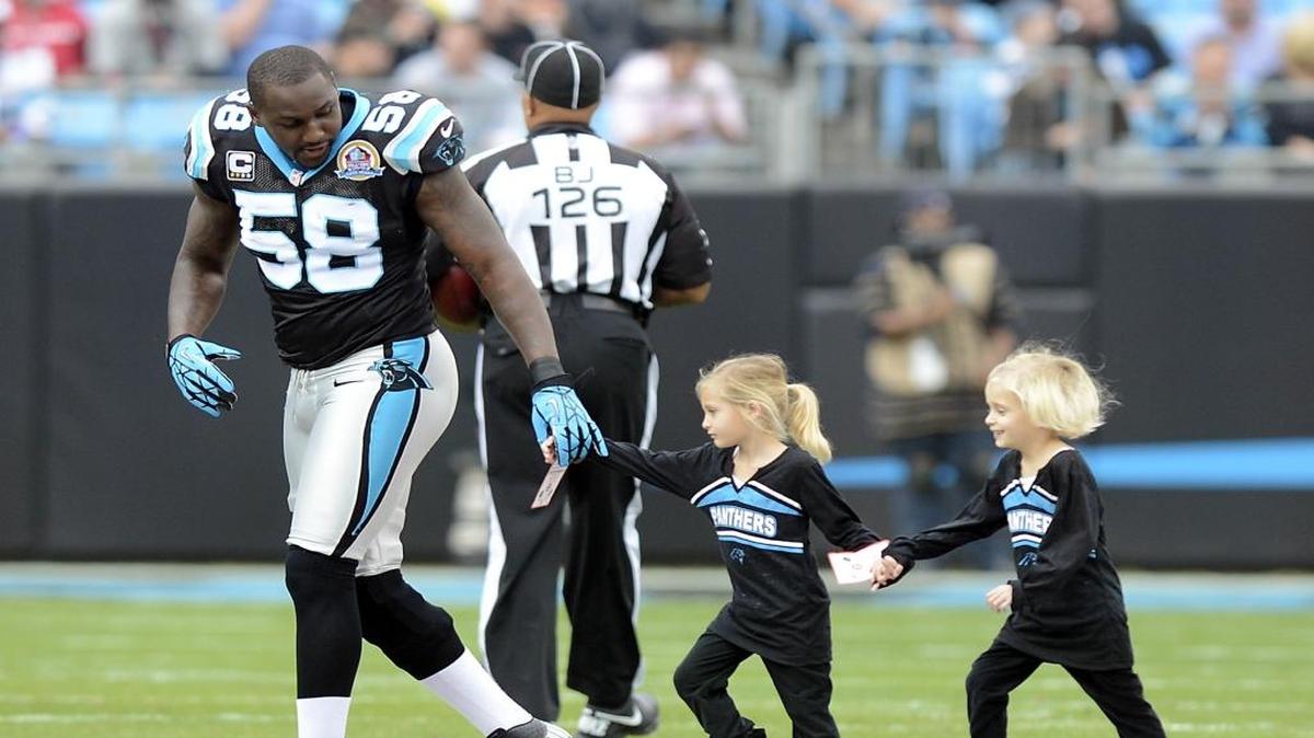 Carolina Panthers' Thomas Davis (58) escorts two children who participated in the coin toss between the Panthers and the Atlanta Falcons' prior to kickoff at Bank of America Stadium on December 9, 2012. The Panthers won, 30-20. David T. Foster III-dtfoster@charlotteobserver.com.