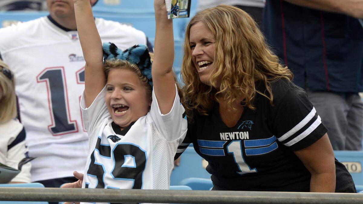 Ella Laurel, 8, and mother Ashley Laurel of Raleigh, NC cheer as they watch the Carolina Panthers warm up prior to playing the New England Patriots in preseason exhibition game at Bank of America Stadium on Friday, August 26, 2016.