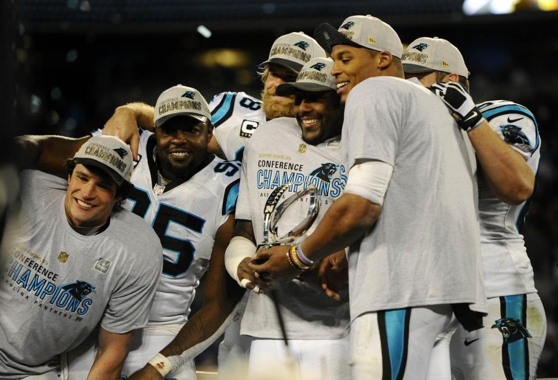 Members of the Carolina Panthers including Luke Kuechly, Charles Johnson, Greg Olsen, Thomas Davis, and Cam Newton hold up the George Halas Trophy after winning the NFC Championship over the Arizona Cardinals on Sunday, January 24, 2016.