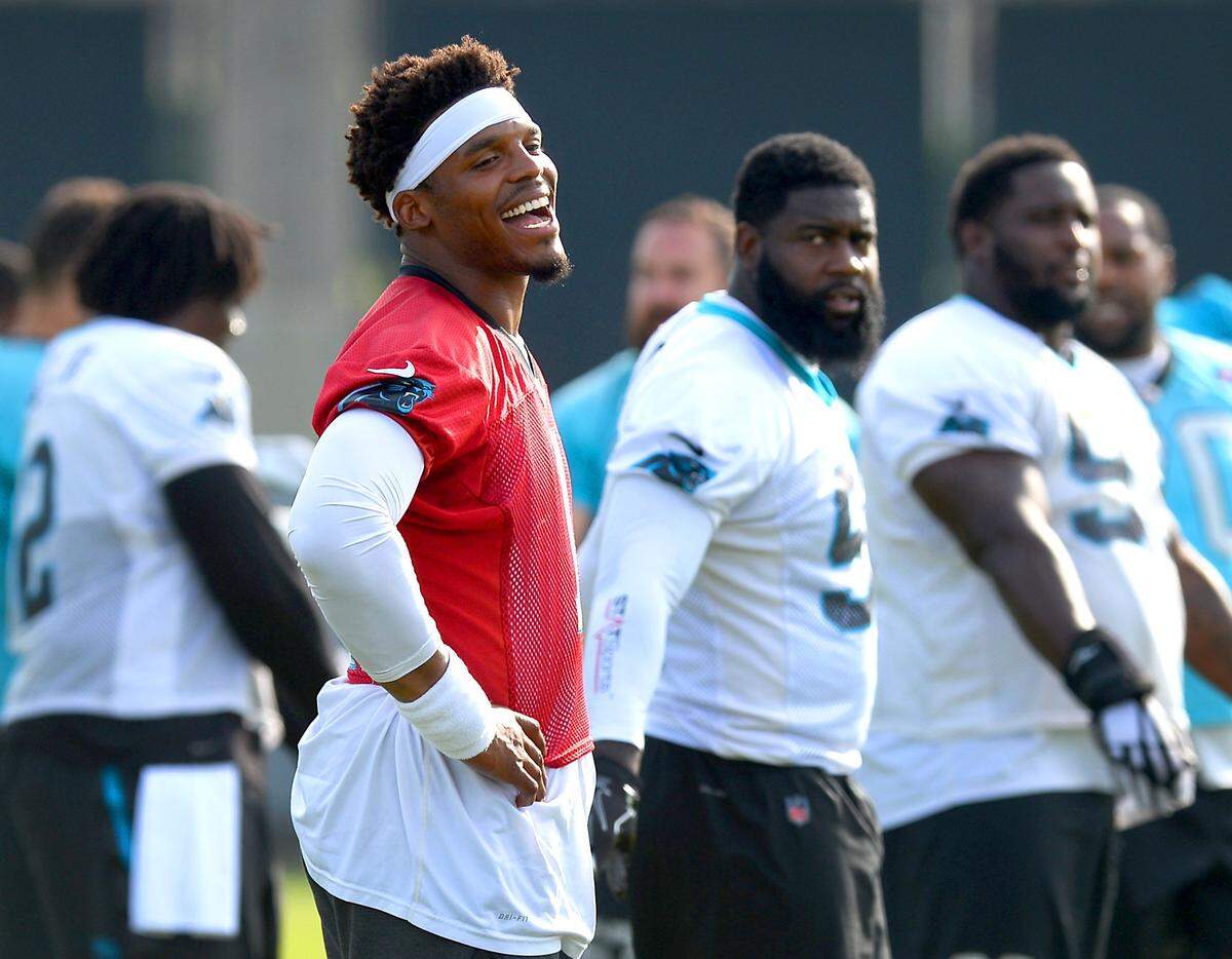 Carolina Panthers quarterback Cam Newton, right, jokes with his teammates as they stretch during the team's final practice of their three day minicamp on Thursday, June 14, 2018.