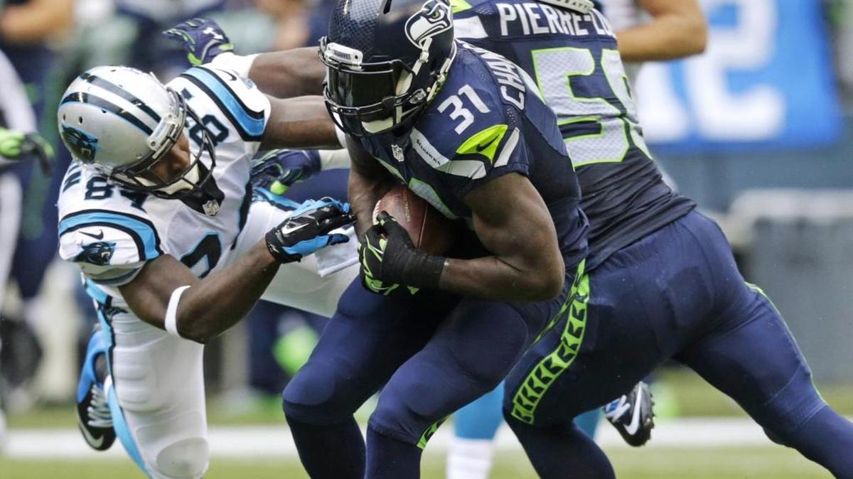 Carolina Panthers tight end Ed Dickson, left, flies toward Seattle Seahawks strong safety Kam Chancellor (31) after Chancellor intercepted a pass in the second half of an NFL football game, Sunday in Seattle.