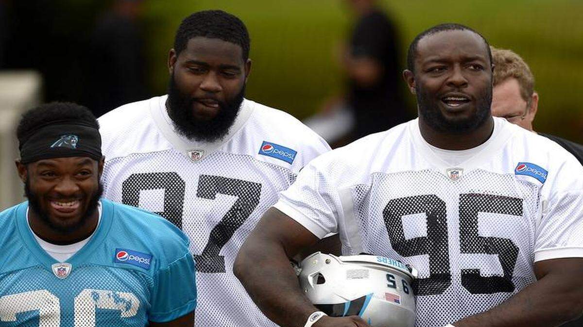 
Carolina Panthers defensive end Charles Johnson, center, gets in his share of trash talking during practice. Thursday he got an extra opportunity – after an interception of quarterback Cam Newton.
