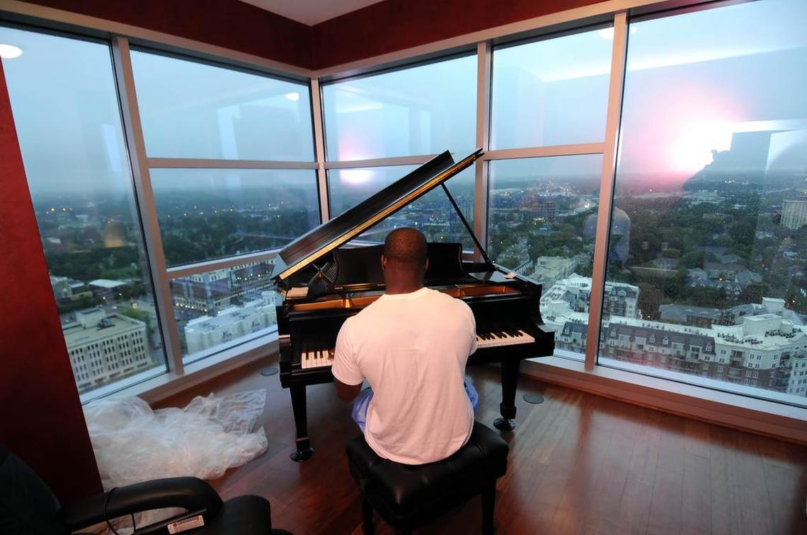 Former Carolina Panthers running Jonathan Stewart is pictured in 2008 playing his baby grand piano in his uptown Charlotte apartment building.