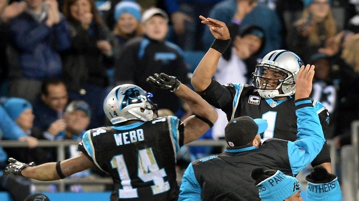 Carolina Panthers quarterback Cam Newton, right, leaps into the air to celebrate a touchdown by running back Cameron Artis-Payne during second quarter action vs the Tampa Bay Buccaneers on Jan. 3, 2016 at Bank of America Stadium in Charlotte, NC. Celebrating with Newton are quarterback Joe Webb, left, and Derek Anderson, center.