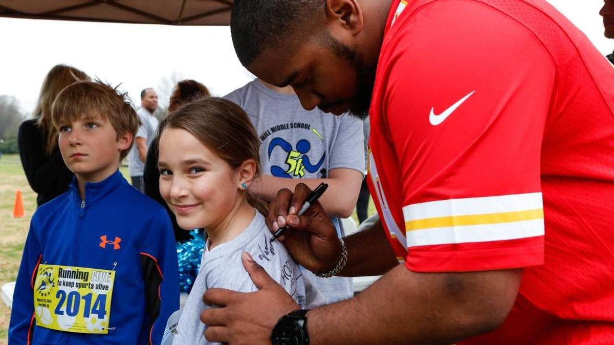 Fort Mill graduate Vance Walker signs his autograph on Hannah Maslowski's shirt during a 2014 fundraiser for the Fort Mill Middle School Booster Club. Walker, now with the Denver Broncos, is getting ready to Play against the Carolina Panthers in Super Bowl 50.