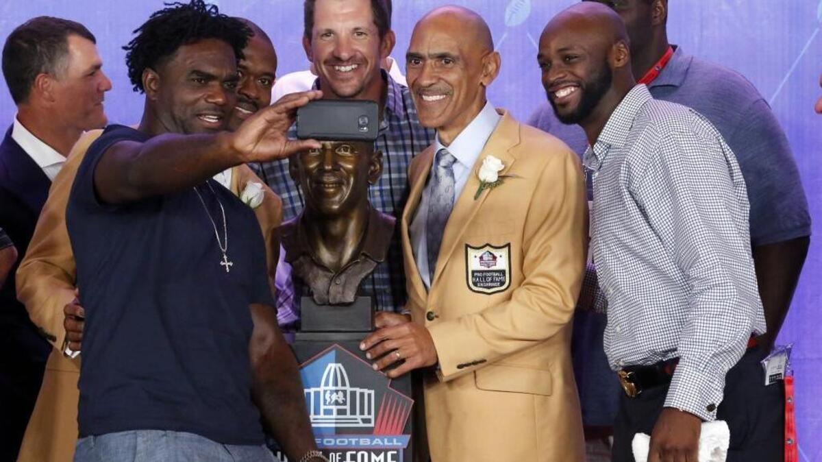 Former NFL coach and player Tony Dungy, center, takes a photo with former NFL running back Edgerrin James, left, and former members of the Indianapolis Colts teams he coached, with his Hall of Fame bust during an induction ceremony at the Pro Football Hall of Fame, Saturday, Aug. 6, 2016, in Canton, Ohio. Dungy said he doesn’t expect a letdown from Carolina this season. (AP Photo/Gene J. Puskar)