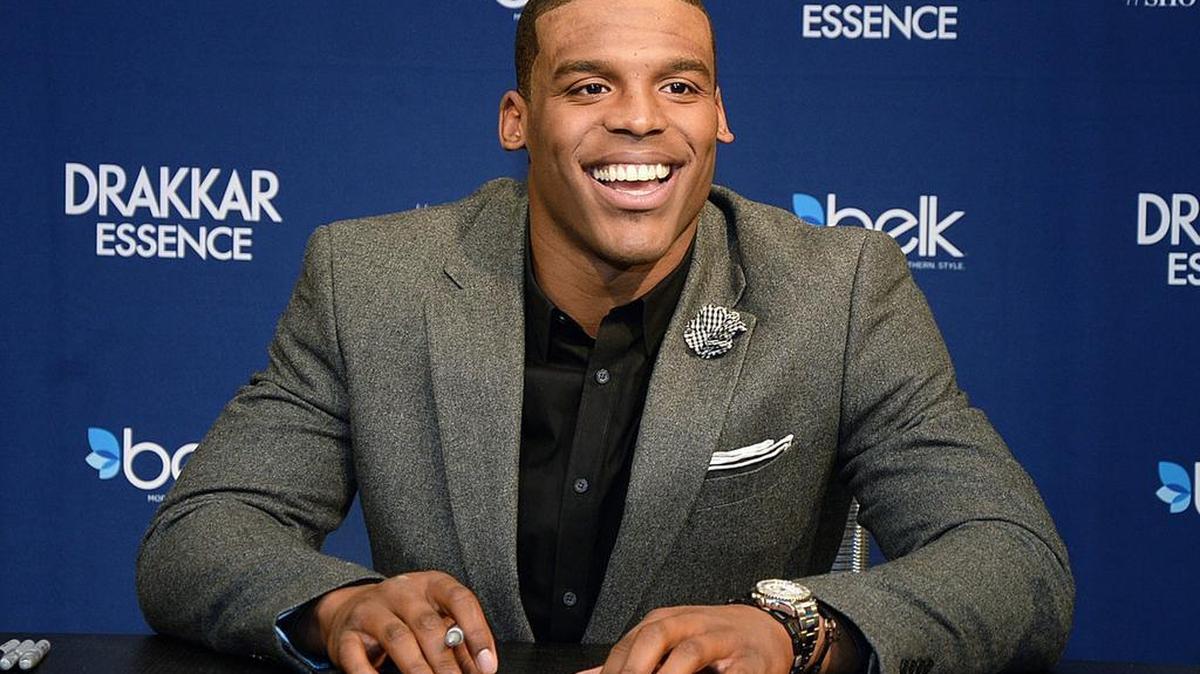 Cam Newton signs bottles of Drakkar Essence for fans at Belk at SouthPark on Nov. 24, 2014.
