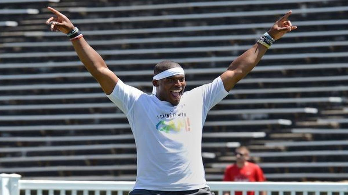 Cam Newton celebrates as he takes the field for his second kickball game at his annual Kick it with Cam! celebrity charity kickball tournament Friday afternoon at Memorial Stadium.