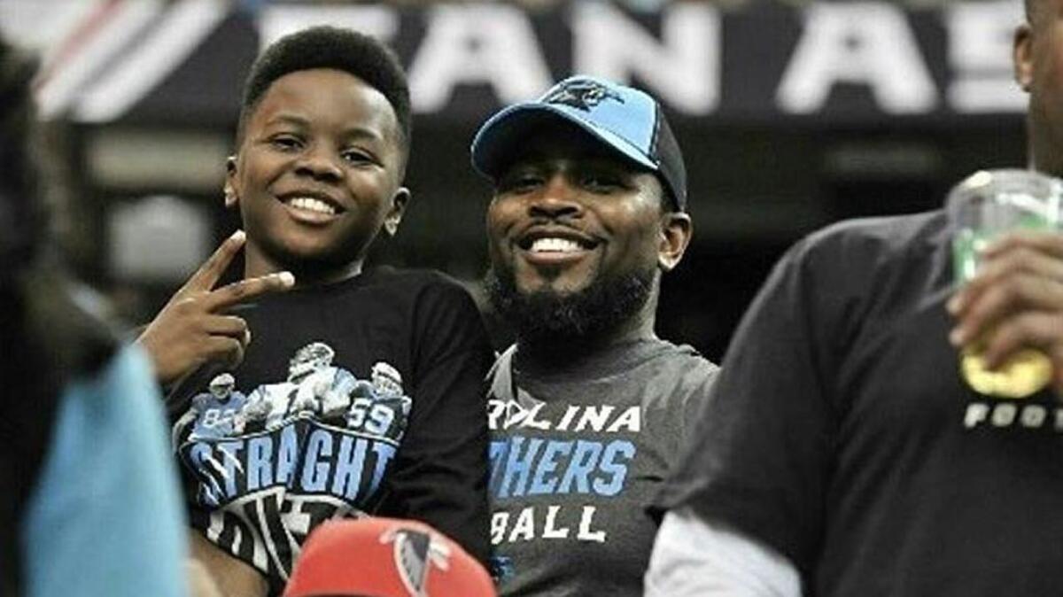 Derek McKnight, right, and his son DJ at a Carolina Panthers game in Atlanta. The McKnights are season ticket holders waiting to find out whether they will get the chance to buy Super Bowl tickets