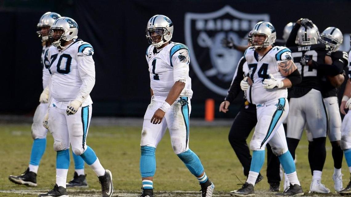 Carolina Panthers quarterback Cam Newton, center, walks to the team's sideline after Oakland Raiders defensive end Khalil Mack stripped the ball from Newton's hand and recovered the ball during late fourth quarter action at the Oakland-Alameda County Coliseum in Oakland, CA. on Sunday, November 27, 2016. At left, Panthers Trai Turner had to play right tackle due to other player injuries. The Raiders defeated the Panthers 35-32.