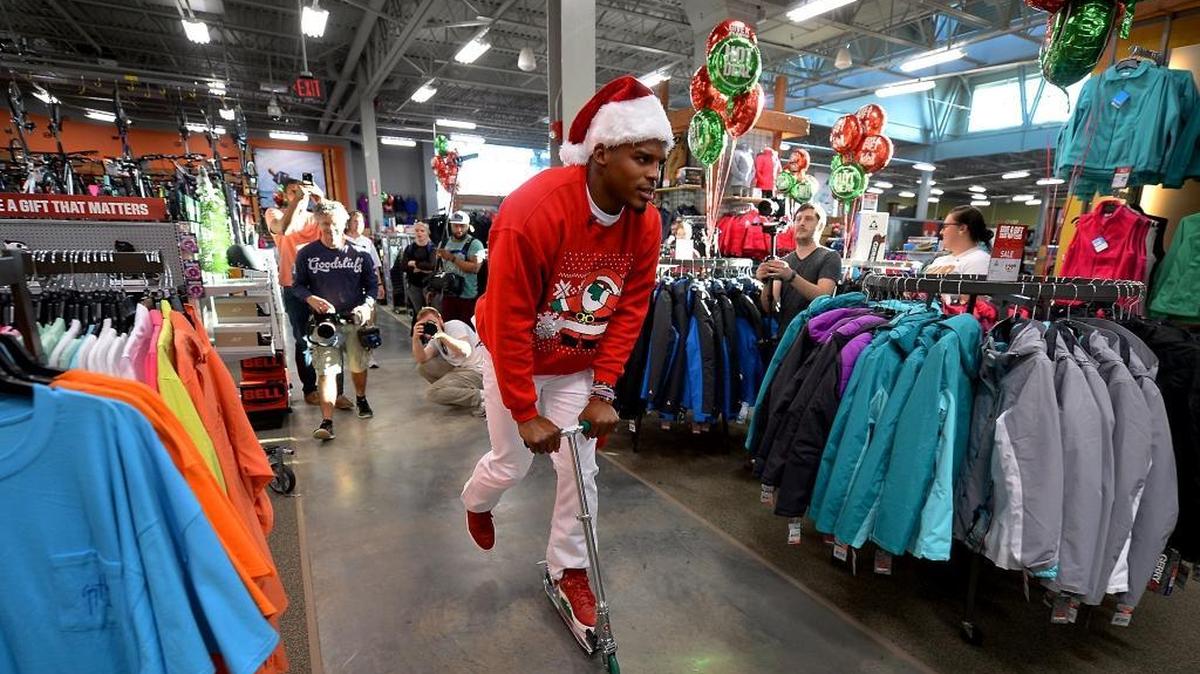 Carolina Panthers quarterback Cam Newton uses a scooter to make his way around the Dick's Sporting Goods store at SouthPark on Tuesday, Dec. 15, 2015, during his Santa Cam Surprise Sleigh event.