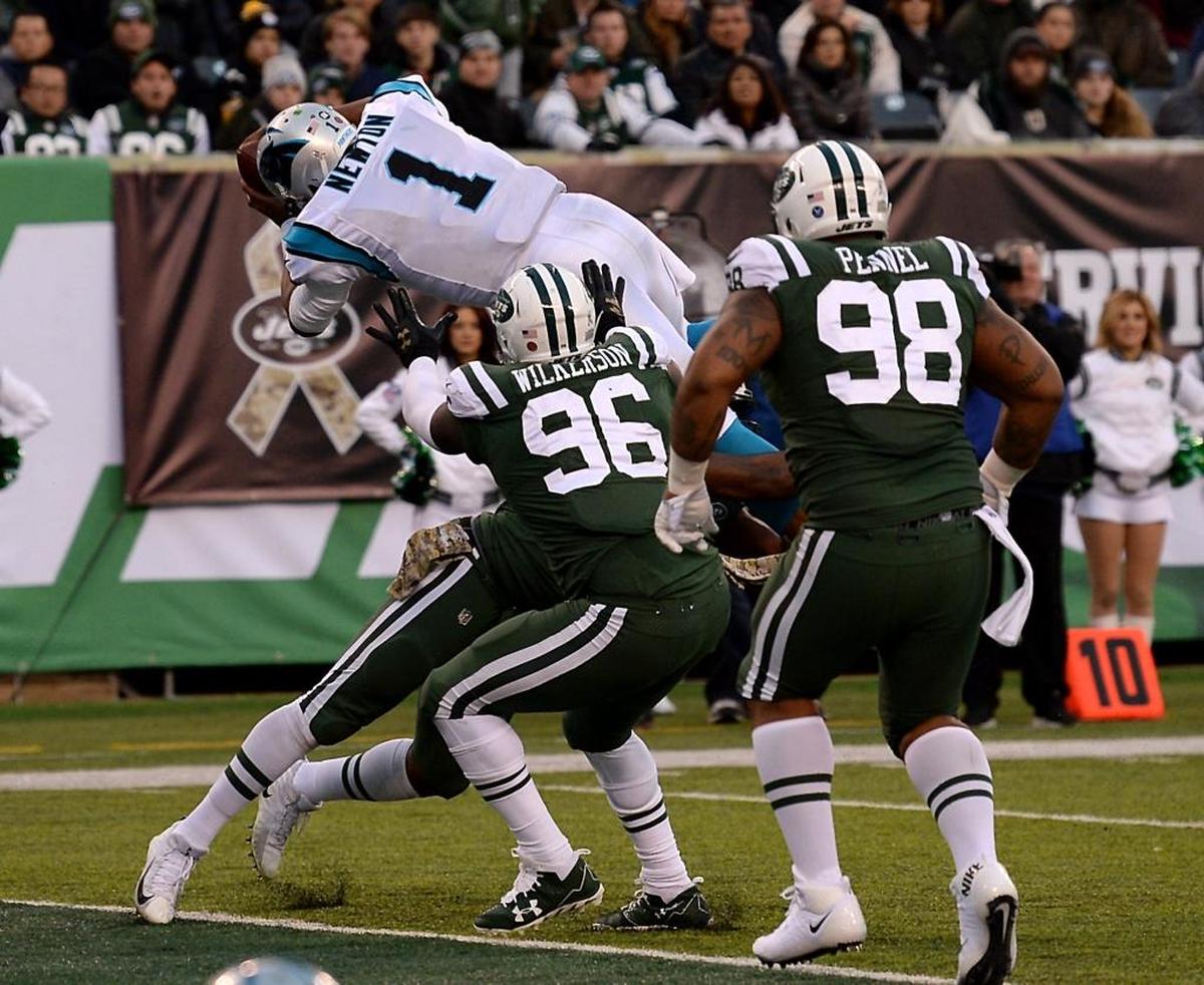 Carolina Panthers quarterback Cam Newton leaps over members of the New York Jets defense for a two-point conversion on Sunday at East Rutherford, N.J., on Sunday. The Panthers defeated the Jets 35-27.