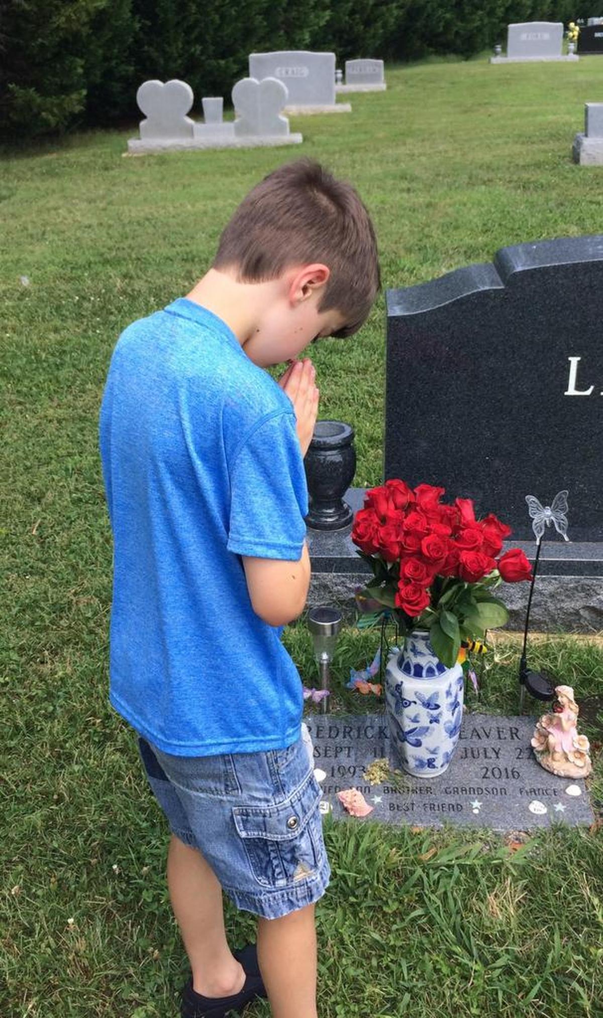 Rick Weaver’s younger son, Lincoln, visits the grave of his brother, Fredrick, who died from an asthma attack on July 22, 2016.