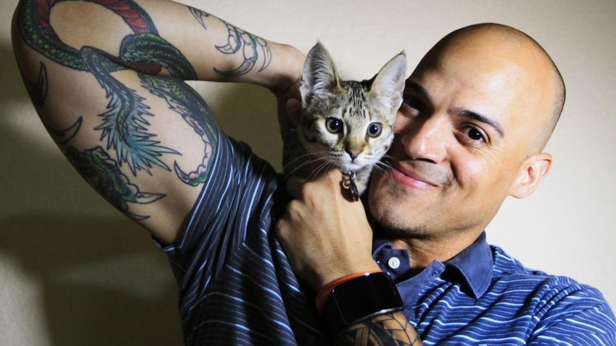 Retired NFL player Jarrod Cooper with resident savannah cat George at Oak Tree Animal Hospital in Danville, Calif., where his volunteer work helps him with his symptoms, on March 11. A former Oakland Raiders safety, Cooper was forced to retire after eight years in the NFL, which included a Super Bowl appearance with the Carolina Panthers, after suffering from migraine headaches. Doctors have diagnosed his condition as frontal lobe dementia, degenerative brain disease and chronic traumatic encephalopathy (CTE), all the direct result from multiple concussions.