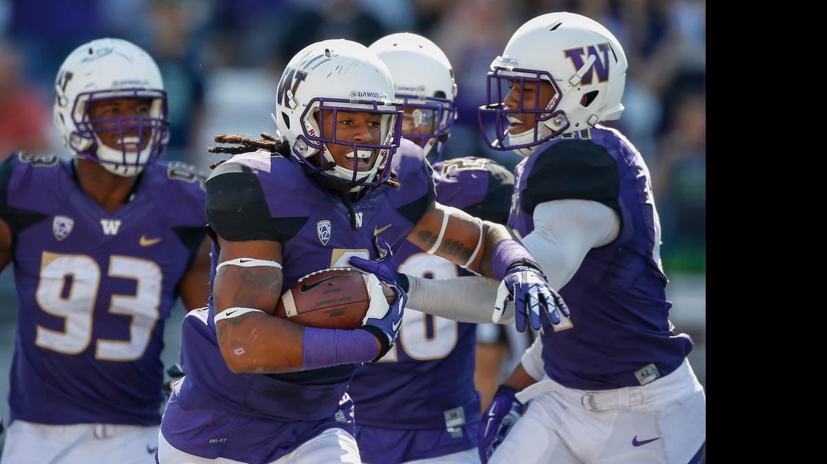 
Washington Huskies linebacker Shaq Thompson (with ball) is congratulated by teammates after returning an interception for a touchdown against the Illinois Fighting Illini on Sept. 13, 2014 in Seattle.
