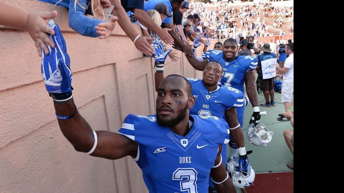 
Duke wide receiver Jamison Crowder, from left, running back Josh Snead and guard Laken Tomlinson are congratulated by fans after Duke beat Virginia 20-13 at Wallace Wade Stadium in Durham, Sept. 18, 2014.
