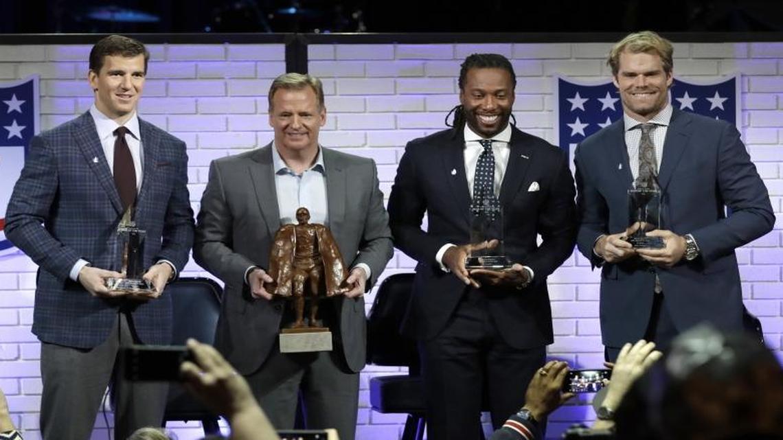 NFL Commissioner Roger Goodell, second from left, poses with Walter Payton NFL Man of the Year finalists, from left, Eli Manning, Larry Fitzgerald and Greg Olsen during a fan forum in Houston on Friday.
