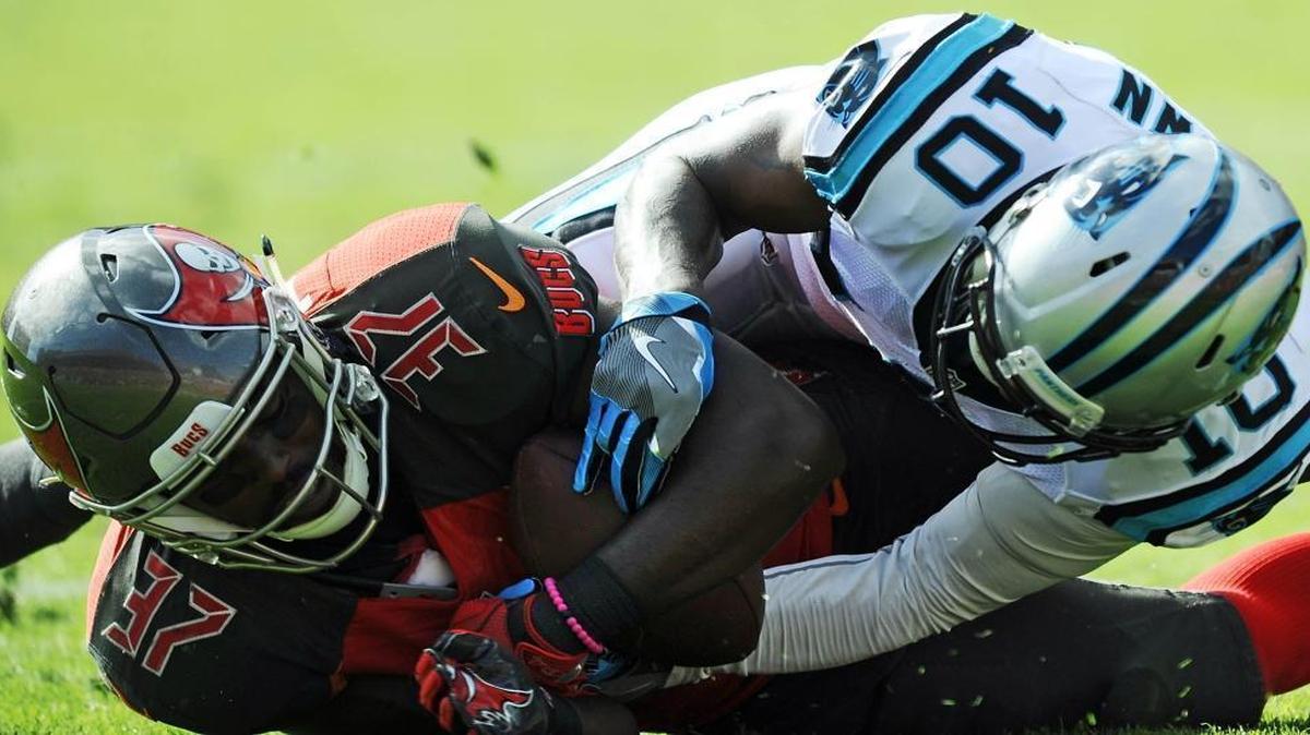 Carolina Panthers wide receiver Corey Brown (10) loses possession of the ball as Tampa Bay Buccaneers strong safety Keith Tandy (37) comes up with an interception in the second quarter Sunday at Raymond James Stadium.