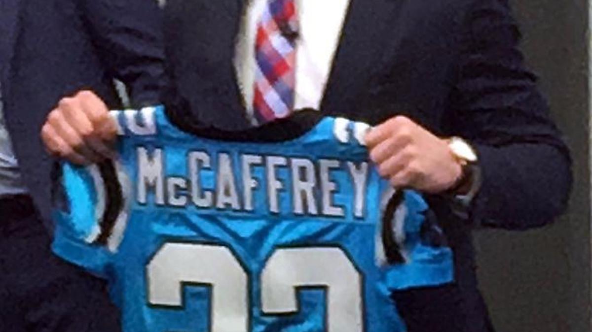 Carolina Panthers rookie running back Christian McCaffrey holds up his jersey as he walks into his news conference for at Bank of America Stadium on Friday.