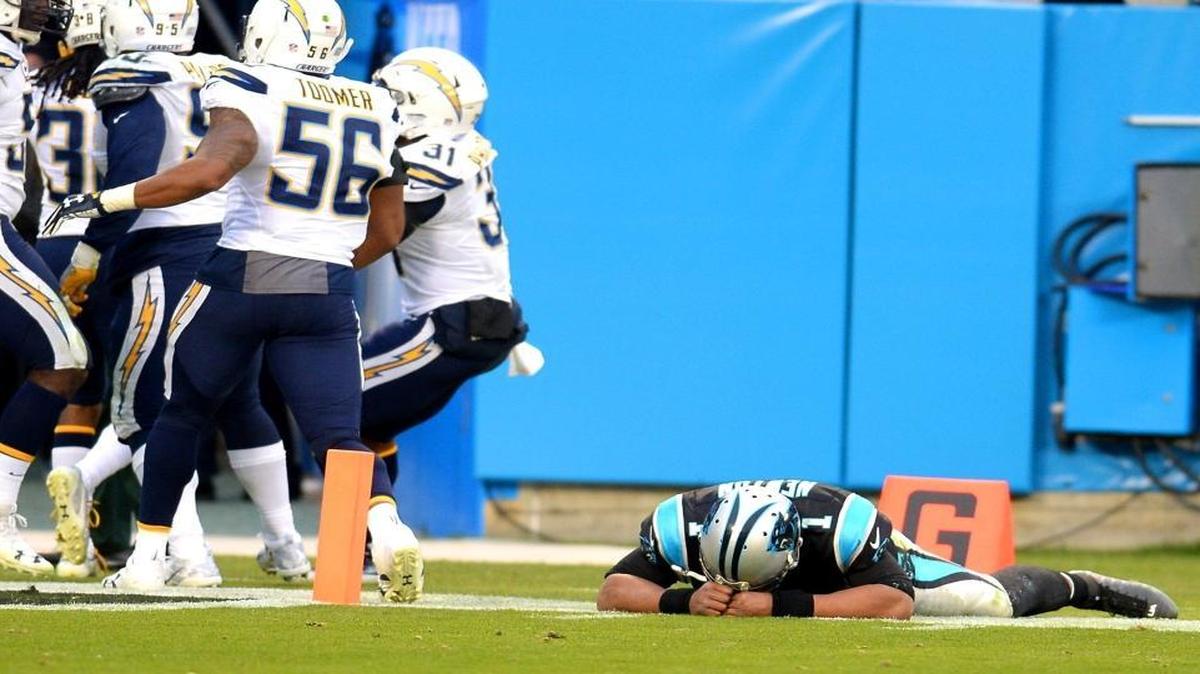 Carolina Panthers quarterback Cam Newton, right, , lays on the turf after failing to stop San Diego Chargers' Trovon Reed from returning an interception for a touchdown during the Dec. 11 game at Bank of America Stadium.