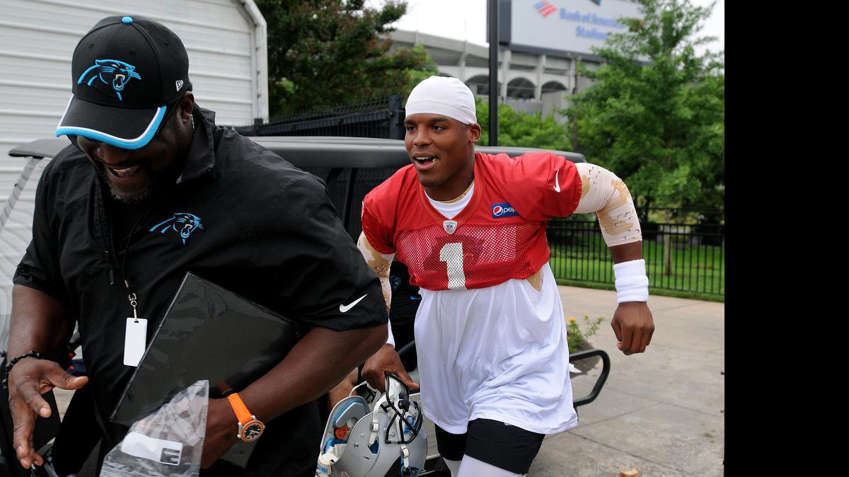 
Carolina Panthers quarterback Cam Newton, right, tries to run around assistant offensive line coach Ray Brown, left, after riding to practice on a Club Car on Thursday, June 4, 2015. Newton was intercepted twice Thursday, one week after having a nearly flawless practice in front of media. 
