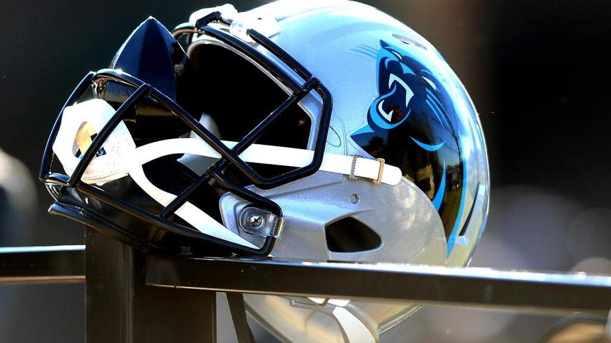 A fan’s Carolina Panthers helmet hangs on the fence outside the team’s practice fields on Thursday.