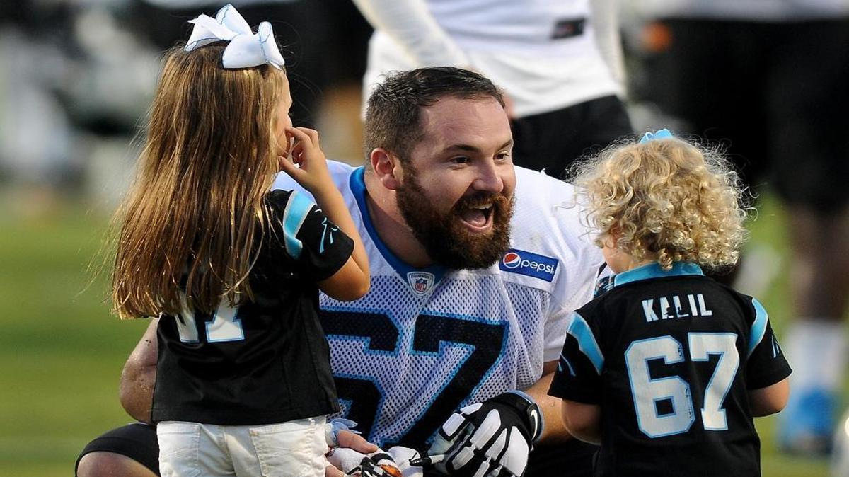 Carolina Panthers center Ryan Kalil, center, greets his daughters, Kenadi, 4 yrs., left, and Chandler, 2, right, following the team's practice at Wofford College in Spartanburg, SC on Friday, July 31, 2015.